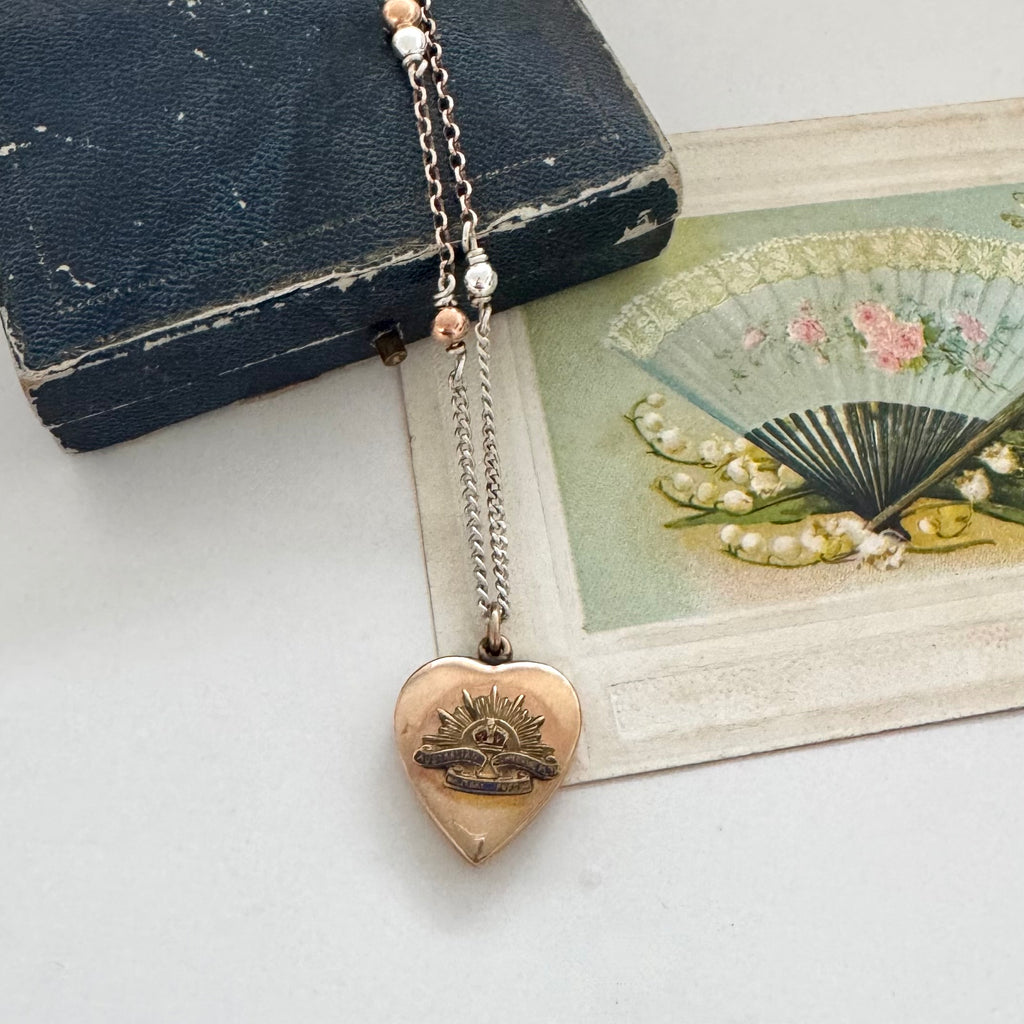 WW2 ACMF heart-shaped pendant sweetheart locket on a chain against an old letter background