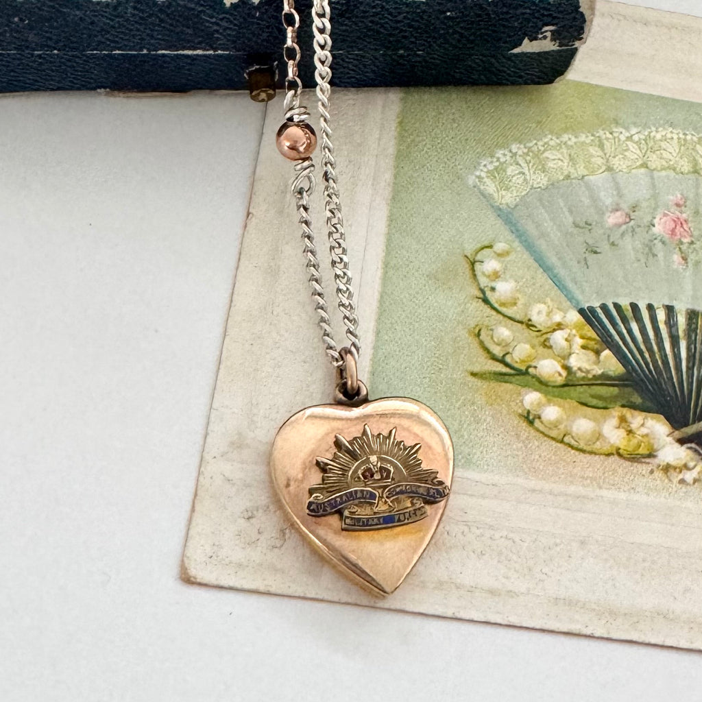 WW2 ACMF heart-shaped pendant sweetheart locket on a chain against an old letter background
