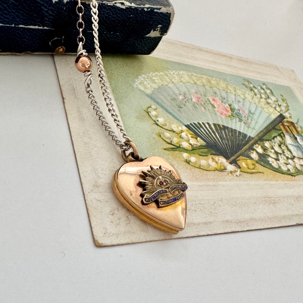 WW2 ACMF heart-shaped pendant sweetheart locket on a chain against an old letter background