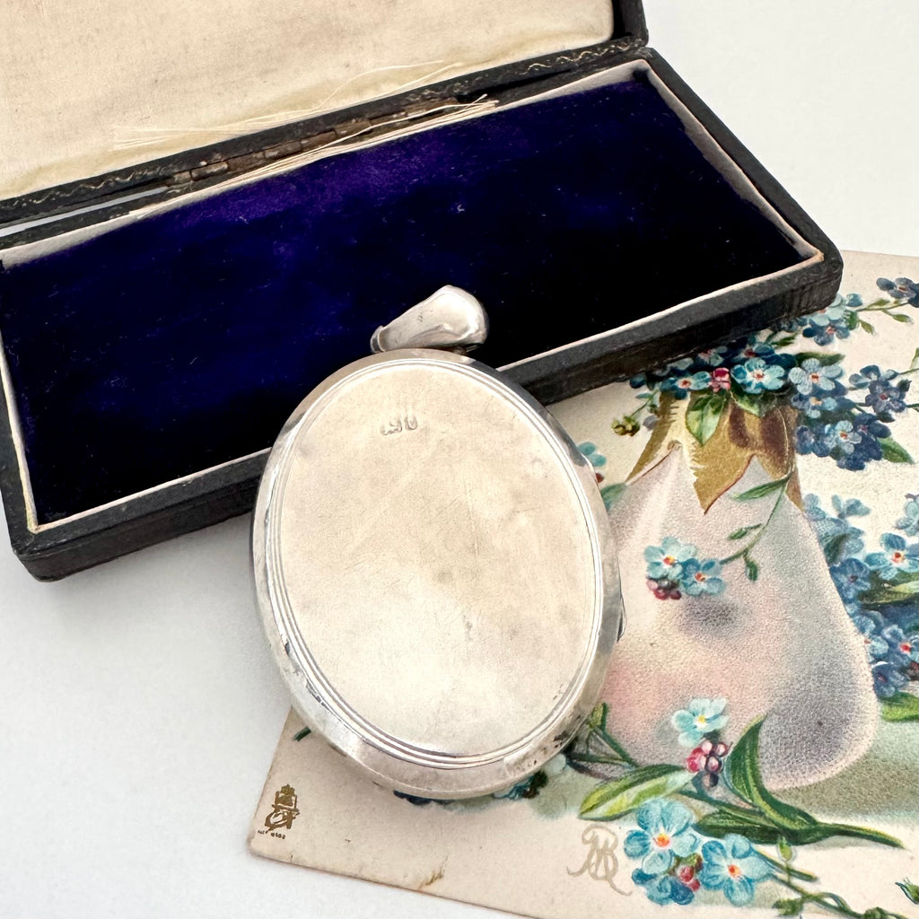 Antique Victorian 1879 locket on a vintage floral card