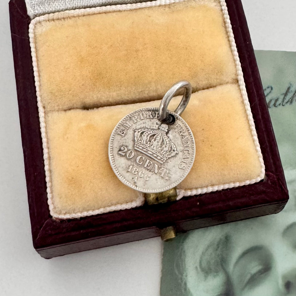 Silver coin pendant with a crown in a velvet-lined box