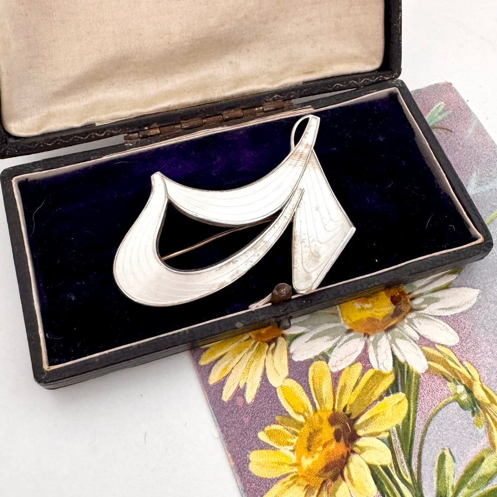 Silver Norwegian Ivar T Holth brooch on a floral card with an open jewelry box in the background