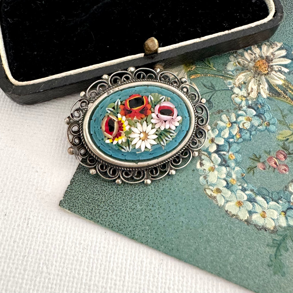 Vintage micro mosaic brooch on an old postcard