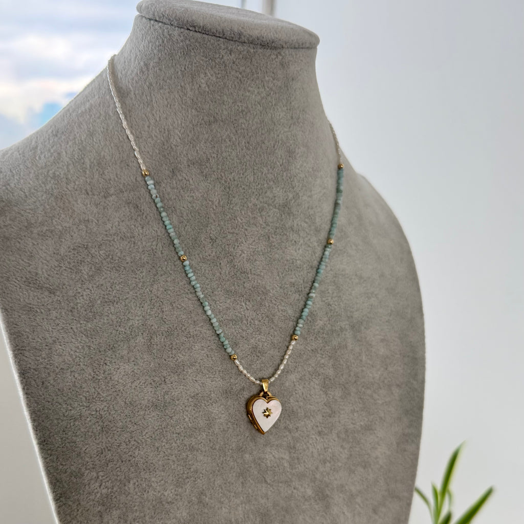 Necklace with a heart pendant on a gray mannequin bust against a light background