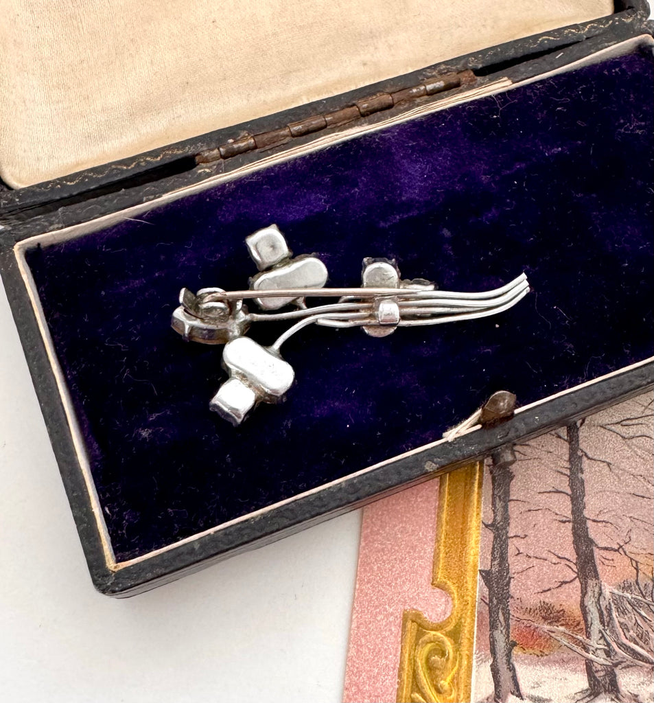 Silver brooch with rhinestones in a black box on a snowy landscape card