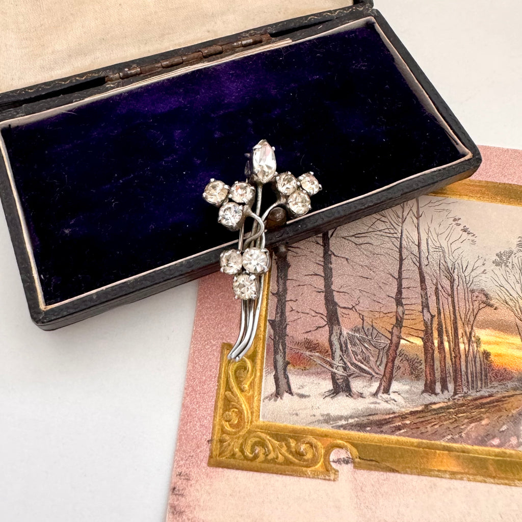 Silver brooch with rhinestones in a black box on a snowy landscape card