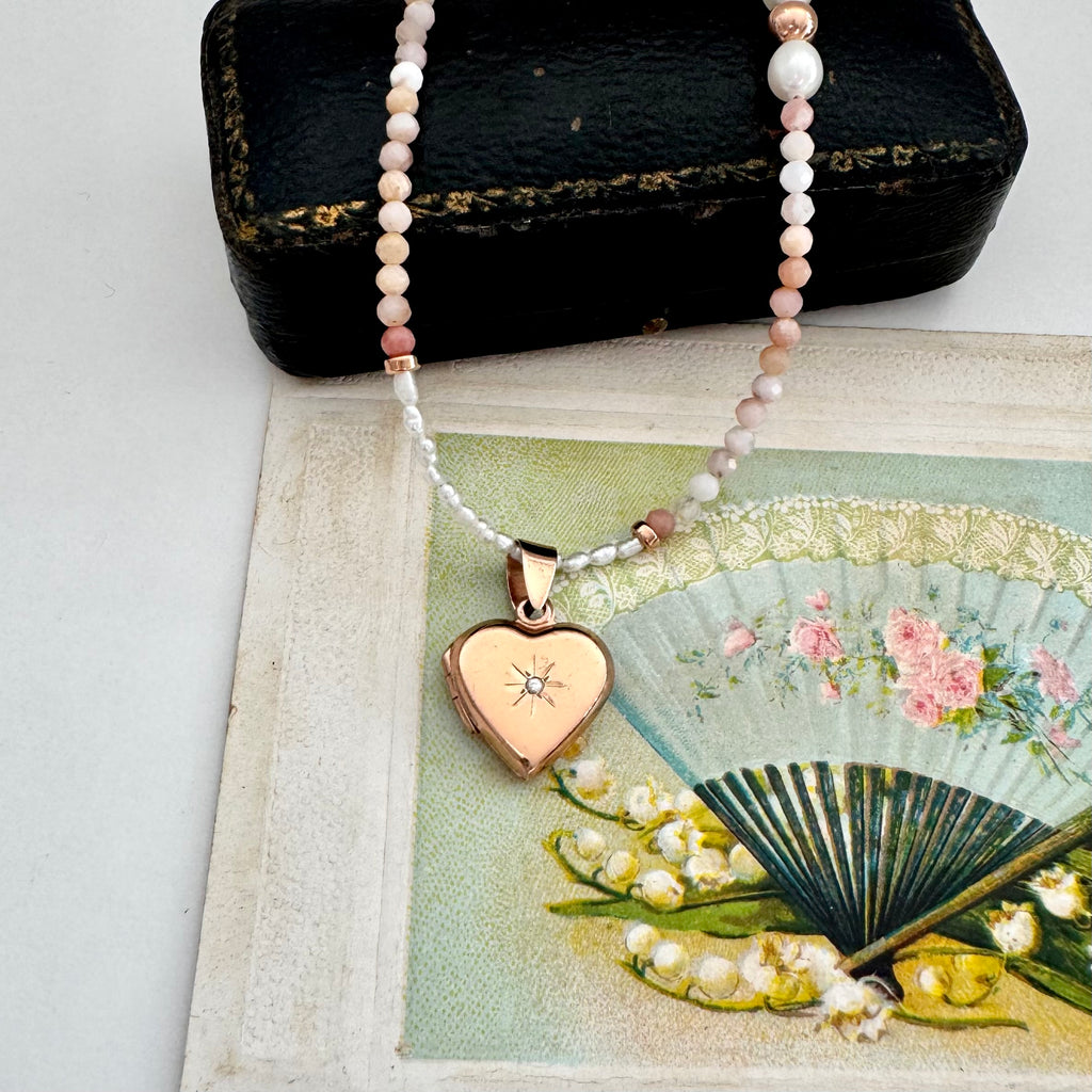 Necklace with a heart-shaped pendant on a vintage-style card with floral design