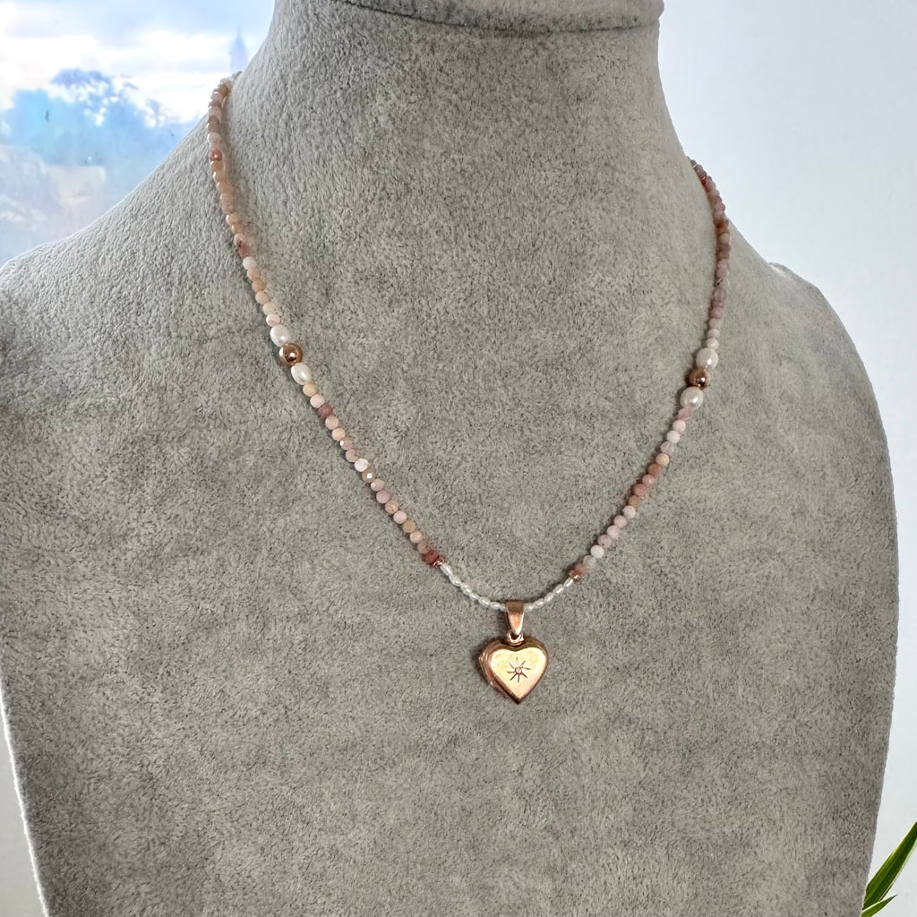 Necklace with a heart-shaped pendant on a mannequin bust against a neutral background