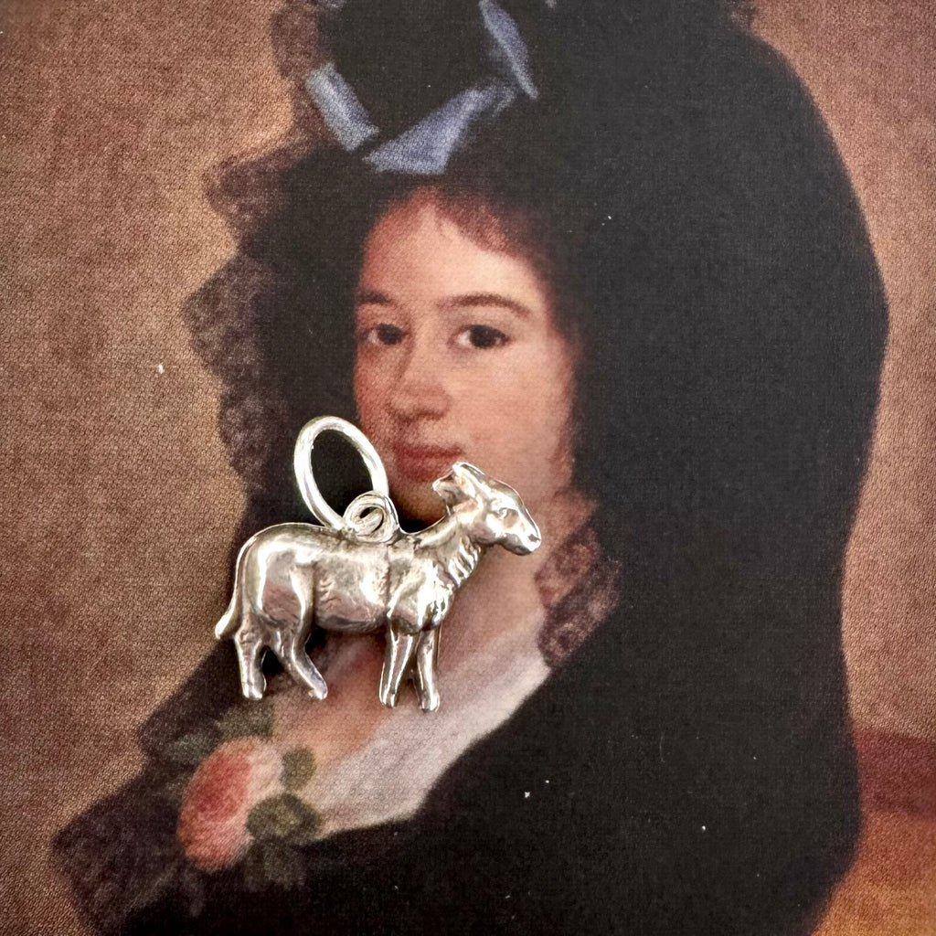 Vintage silver goat charm on an Old masters portrait of a Spanish woman
