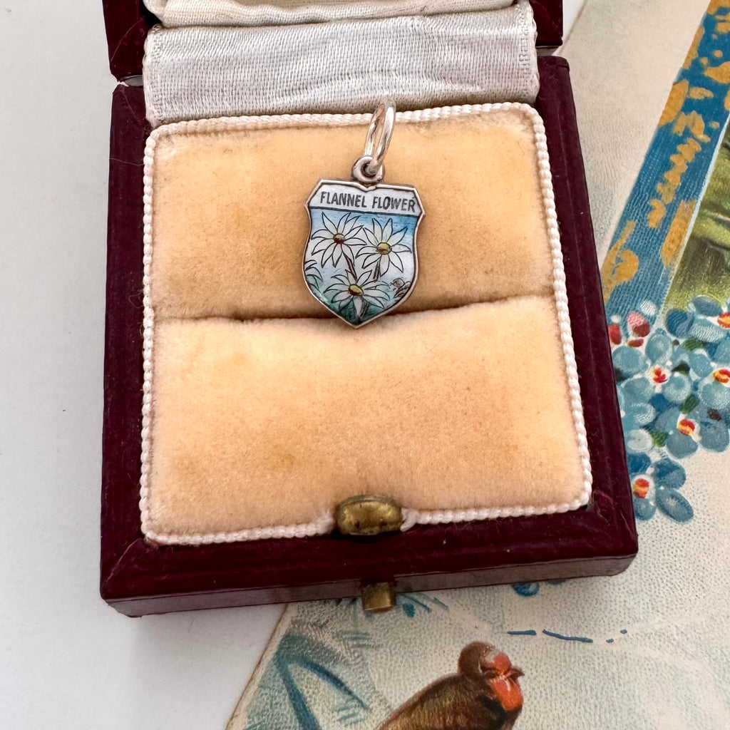 Flannel Flower charm in a jewelry box with floral background