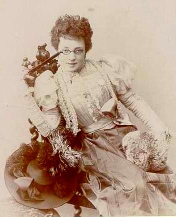 Vintage photograph of a woman in an elaborate dress with decorative elements.