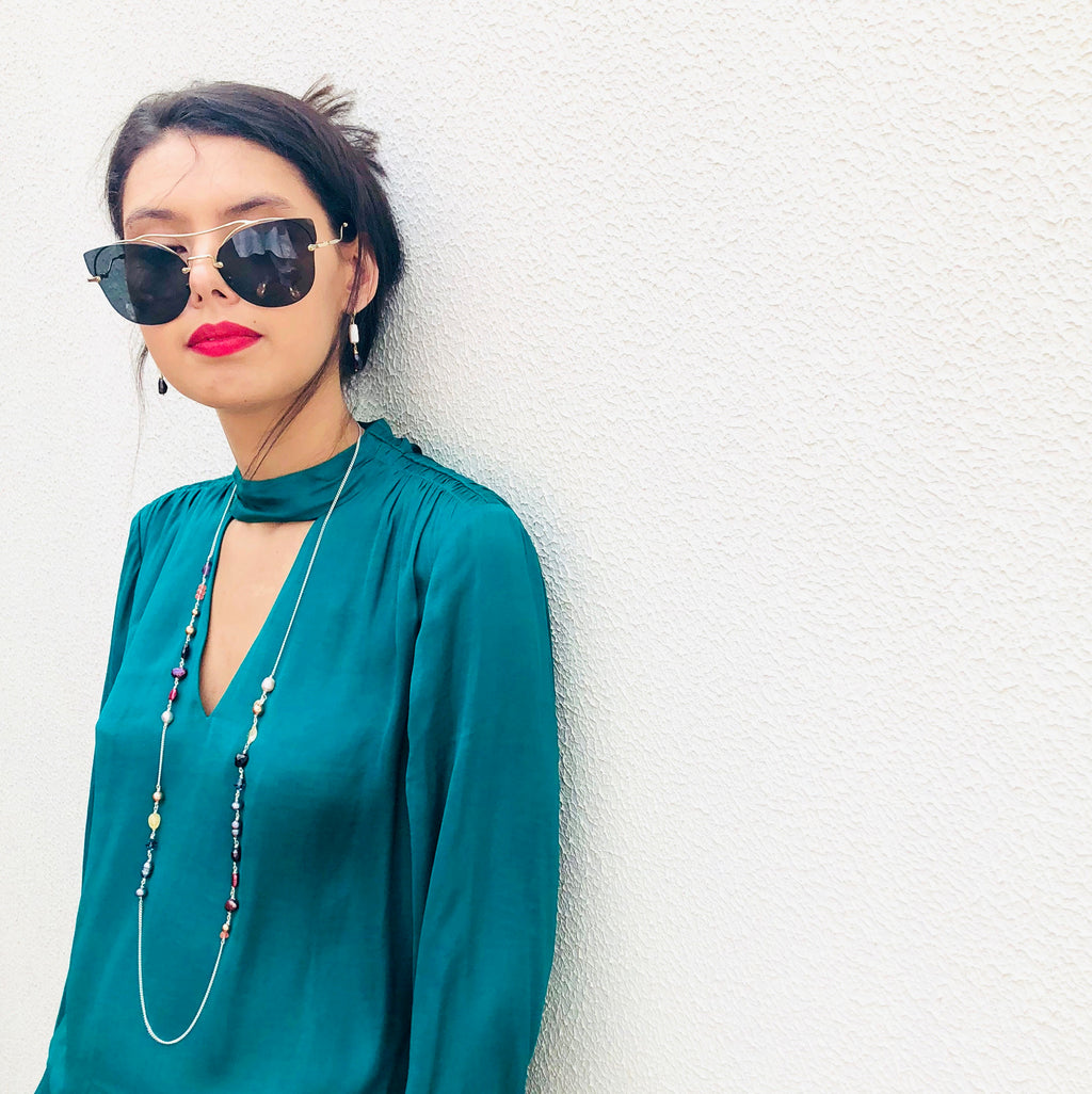 Image of model wearing Leoni & Vonk one of a kind jewellery wearing a green shirt and leaning against a white wall