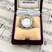 Antique 1918 silver threepence charm or pendant in a box on sheet music