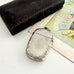 Antique 1879 Victorian silver vesta case on a white background with a vintage postcard and old box in the background.