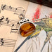 Antique 1891 silver and citrine spinning fob on an old sheet of music with bird illustrations.
