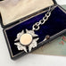 Antique 1898 sterling silver watch fob and chain on an old jewellery box and with an old postcard