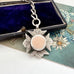 Antique 1898 sterling silver watch fob and chain on an old jewellery box and with an old postcard