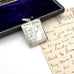 Antique silver stamp case with intricate design on a vintage letter