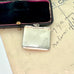 Back of antique 1911 Crisford & Norris silver stamp case with 'STAMPS' in blue enamel in a black box with red interior.