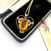 Antique heart-shaped pendant with a yellow gemstone in a black jewelry box