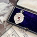 Antique silver and red enamel Lion Rampant watch fob pendant on a sheet of music