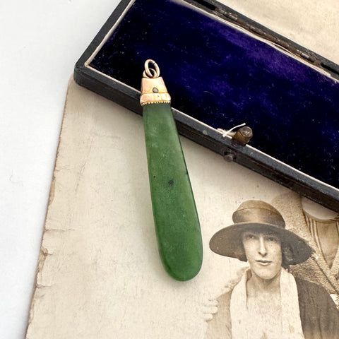 Antique 9ct rose gold and greenstone pendant  on a vintage photograph