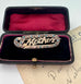 Edwardian 9ct gold silver lined 'Mother' brooch with turquoise and seed pearls in a black case with red interior on an old letter background