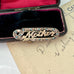 Edwardian 9ct gold silver lined 'Mother' brooch with turquoise and seed pearls in a black case with red interior on an old letter background