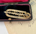 Back of Edwardian 9ct gold silver lined 'Mother' brooch with turquoise and seed pearls in a black case with red interior on an old letter background