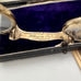 Vintage eyeglasses with 'Carpenter & Westley' engraving on a purple cushioned base.