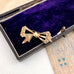 Antique gold lined silver  bow-shaped brooch on an old jewellery box