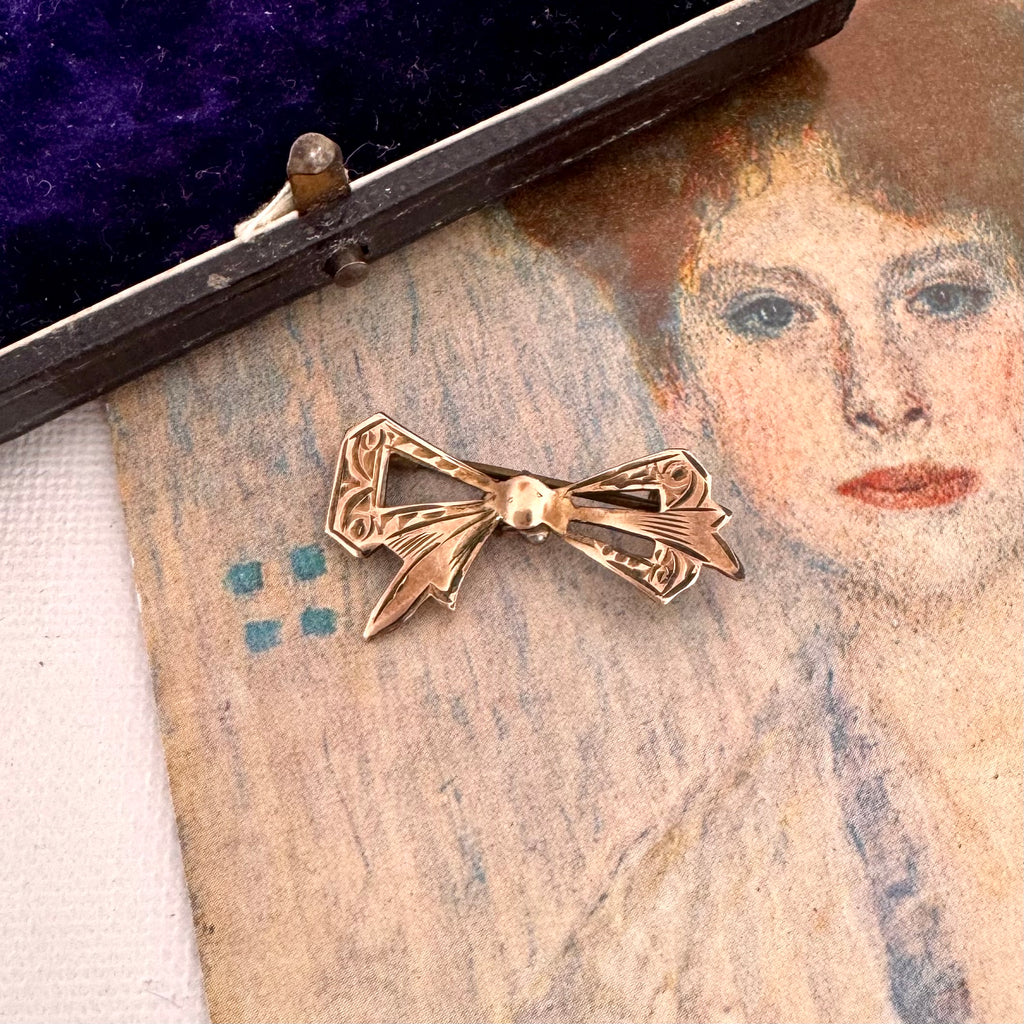 Antique gold lined silver  bow-shaped brooch on an old portrait