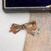 Back of antique gold lined silver  bow-shaped brooch on an old portrait