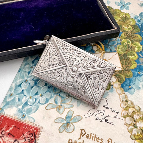 Decorative antique sterling silver stamp case on a floral and vintage-style background