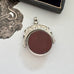 Antique 1896 Chester hallmarked carnelian and bloodstone spinning fob on a jewellery box.
