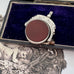 Antique 1896 Chester hallmarked carnelian and bloodstone spinning fob on a jewellery box.