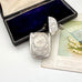 Antique sterling silver 1887 vesta case with intricate patterns on a white surface next to an open jewelry box and vintage card.