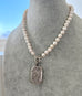 Pearl necklace with a sterling silver antique vesta case pendant on a mannequin bust.