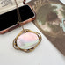 A Victorian oval brooch/pendant necklace with a iridescent mother-of-pearl center and an organic-shaped gold frame, displayed next to a open vintage presentation box and a decorative card.