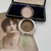 Antique silver compact with a portrait of a woman on a white background