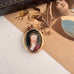 Antique rolled gold locket with hand painted portrait on a vintage postcard