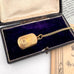 Antique pinchbeck vinaigrette on a chain with an old document in the background and on an open jewellery box