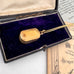 Antique pinchbeck vinaigrette on a chain with an old document in the background and on an old jewellery box