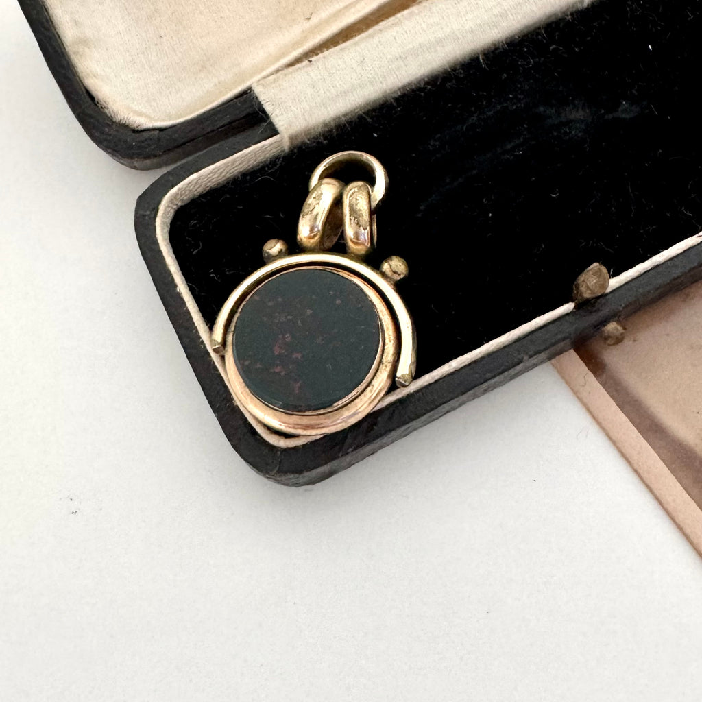 Antique carnelian and bloodstone rolled gold spinning fob on an old jewellery box
