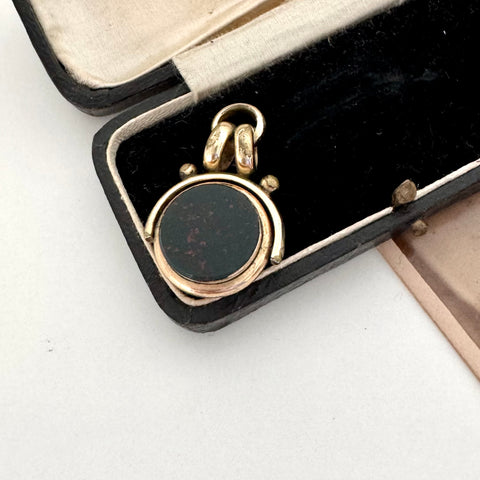 Antique carnelian and bloodstone rolled gold spinning fob on an old jewellery box