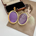 An open Victorian locket showing the inserts for photos displayed open on top of a vintage photograph and jewelry box.