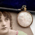 Antique rolled gold and mother of pearl pendant with decorative case on an old photograph of a woman