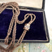 Antique A.H.B & C rolled rose gold guard chain with opal slider on an old postcard.