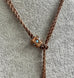 Antique A.H.B & C rolled rose gold guard chain with opal slider on a grey mannequin
