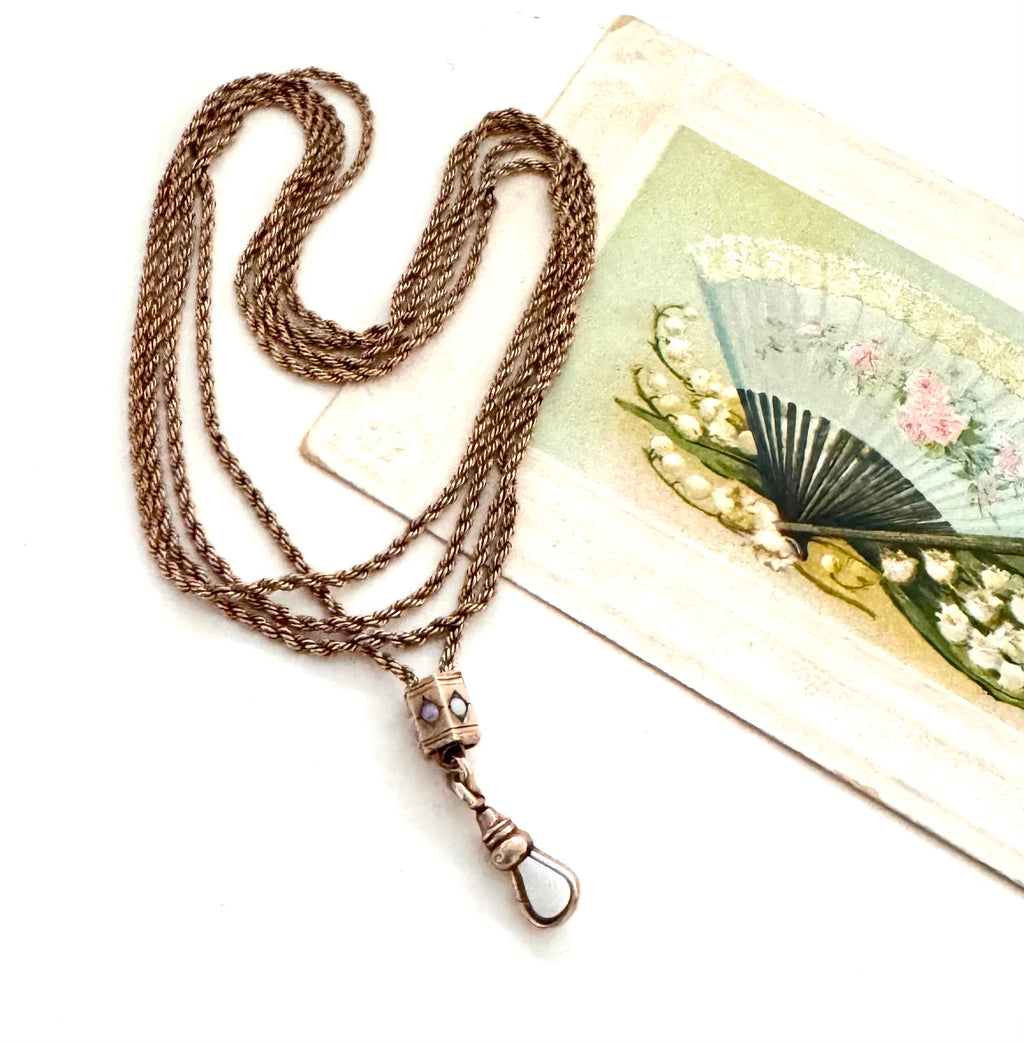 Antique A.H.B & C rolled rose gold guard chain with opal slider on an old postcard.